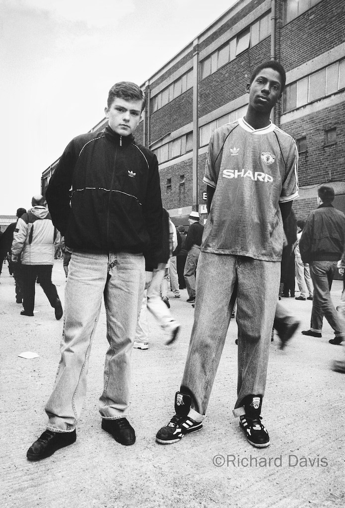 Two United fans pose for the camera outside Old Trafford in March 1991. Copyright: Richard Davis