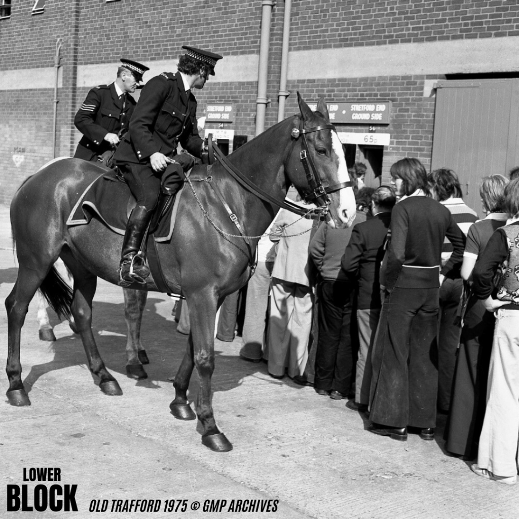 Old Trafford, 1975: Manchester United fans in flares, big collars, scarves, boots and sharp ’70s cuts queue for the Stretford End - admission 65p - as mounted police keep order.